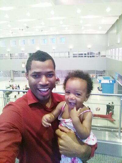 Kimroy Bailey with Keilah Trott Bailey in America where the Trott Bailey FAmily lived while world schooling Keilah. She was about 8 months old in this photo smiling with her buff body daddy.
