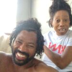 A smiling man with dreadlocks