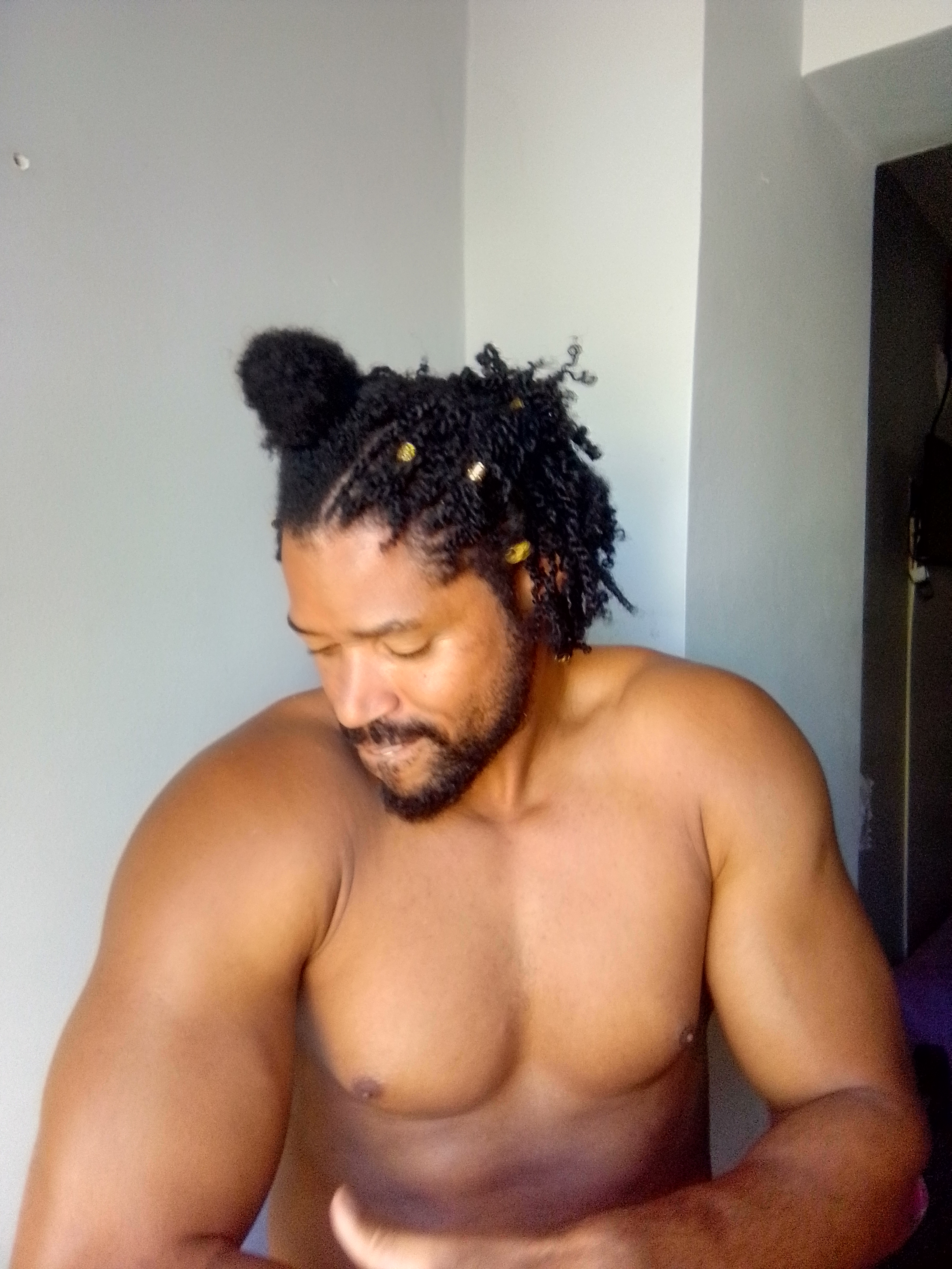 Big King Kimroy Bailey looking down on his tight abdominal muscles over to the side that are naturally built from an active life without the need for gym nor fake muscle products such as pills, shakes, injections, steroids nor surgeries. Built from a fun filled active life with his wife and kids