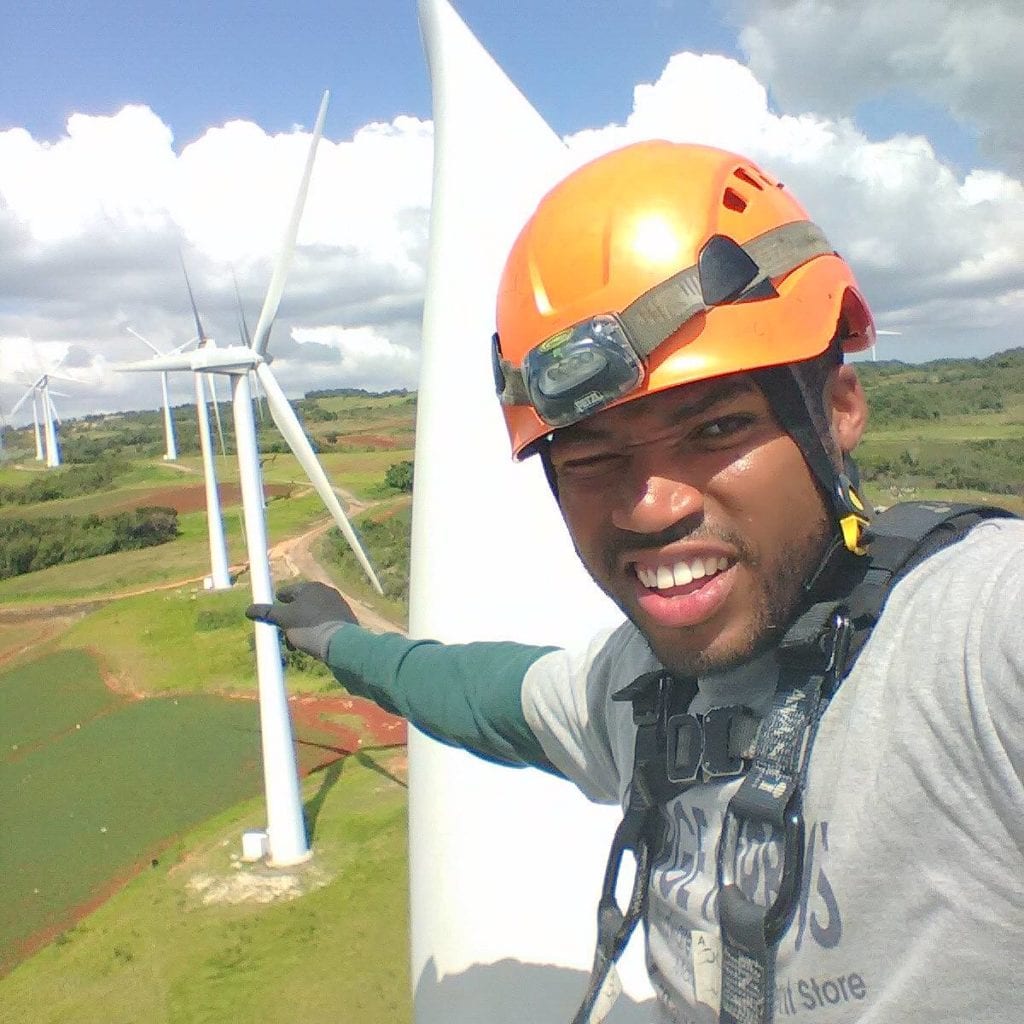 Before starting the Trott Bailey Family Group, Kimroy worked as a wind turbine engineer at the Wigton Windfarm Ltd. This is a photo taken while he was servicing a wind turbine in his helmet and a harness at Wigton in South Manchester Jamaica