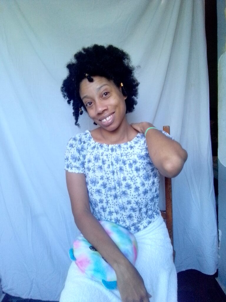 Quadrillionaire Sher Trott Bailey big puffy natural hair rubbing her shoulder after designing some amazing fashion for the Trott Bailey Family Kingdom.